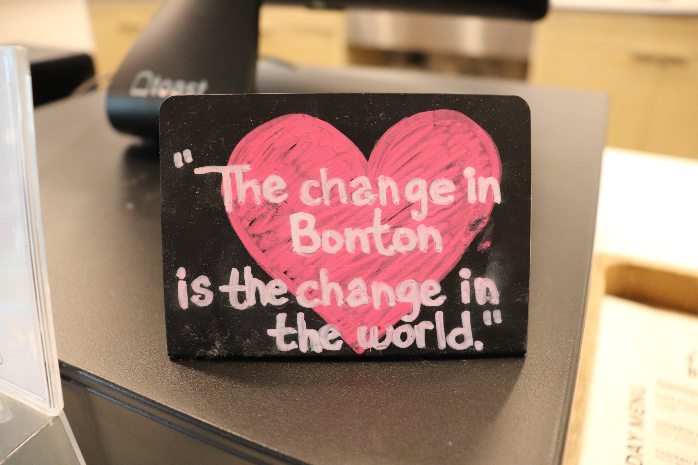 Placard that shows the motto of Bonton Farms. It states, "The change in Bonton is the change in the world"